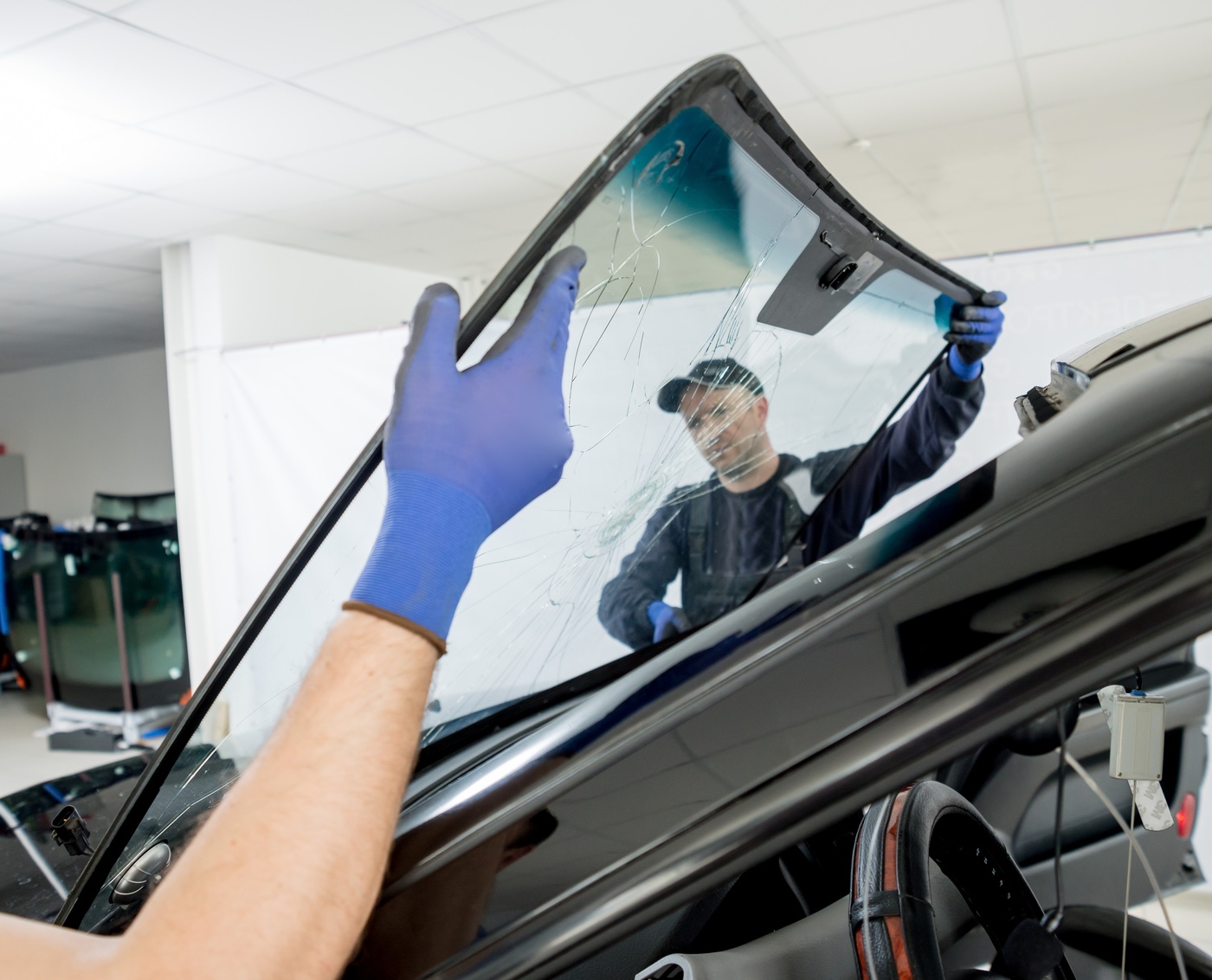 Skilled technician carefully completing an auto glass window replacement in Puyallup, WA.